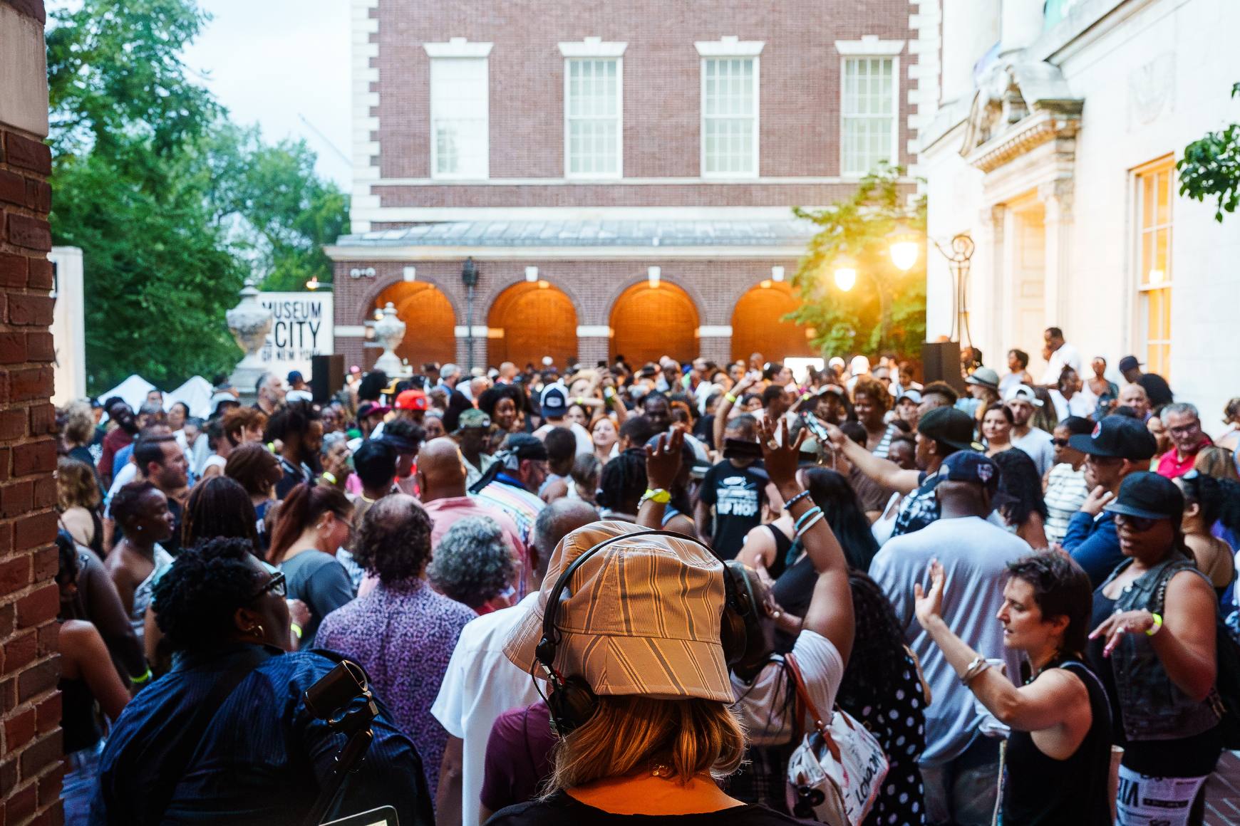 The back of DJ Misbehaviour's head is visible in front of a sea of dancers on The Museum's front terrace.